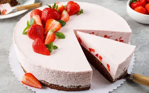 Ein köstlicher Erdbeer Schmand Kuchen in Springform, dekoriert mit frischen Erdbeeren und Minze. Ein Stück wurde bereits entnommen.