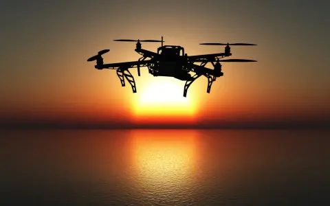 Drohne fliegt über dem Meer bei Sonnenuntergang. Bevor Sie abheben, müssen Sie Ihren Drohnenflug anmelden.