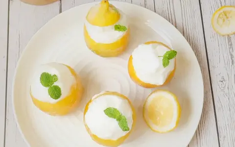 Délicieux citron givré, des citrons évidés remplis de sorbet et décorés de menthe fraîche. Un dessert rafraîchissant et visuellement attrayant.