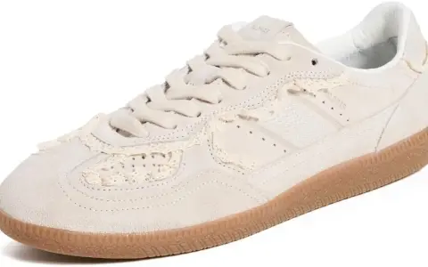 Zapatilla deportiva de ante color crema con detalles de encaje a crochet y suela de goma.
