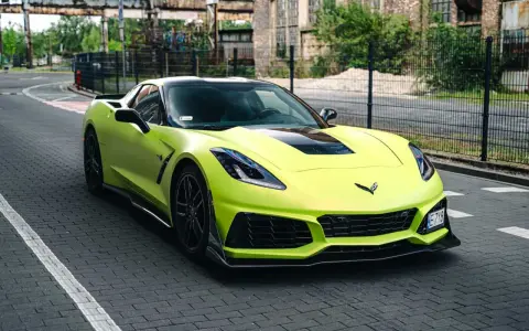 Jasnozielony Chevrolet Corvette C7 na brukowanej drodze. Zastanawiasz się nad corvette c7 cena?
