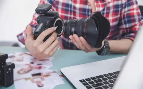 Fotograf przygotowuje sprzęt. Zastanawia się, czy robienie zdjęć z ukrycia jest karalne, przeglądając wydrukowane fotografie.