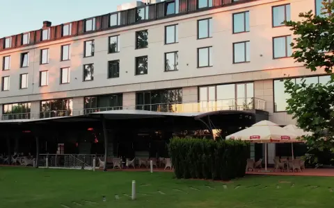Nowoczesny hotel z tarasem i ogródkiem, gdzie można usiąść. Czy to jeden z hoteli Hilton w Warszawie?