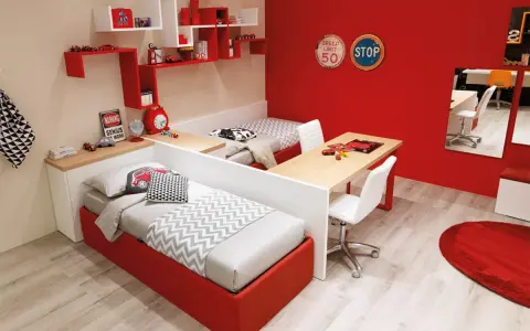 Soluzione creativa per come dividere cameretta maschio e femmina: due letti separati da una scrivania, con arredi a tema auto.