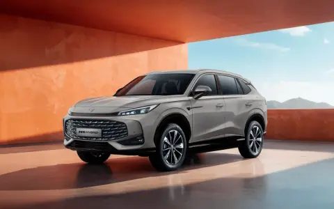 Nowy samochód MG HS Hybrid+ prezentuje się nowocześnie na tle pomarańczowej ściany i błękitnego nieba.