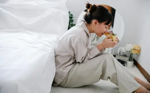 Mujer con taza de té, buscando remedios caseros para dormir de un tirón.