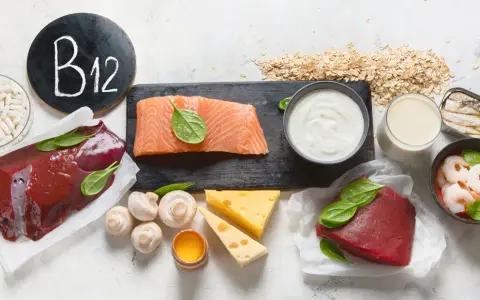 W czym jest witamina B12? Na talerzu wątróbka, łosoś, wołowina, krewetki, sardynki, ser, jajko, jogurt, mleko, płatki owsiane i kapsułki.