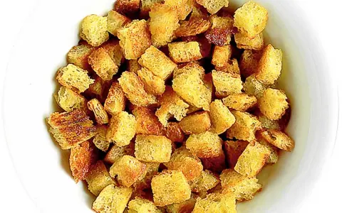 En skål med gyllene krutonger i ugn, perfekta för soppan eller salladen.