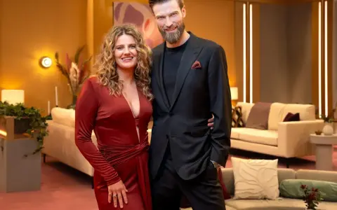 Para Netflix co obejrzeć? Para w eleganckich strojach pozuje na tle przytulnego wnętrza.