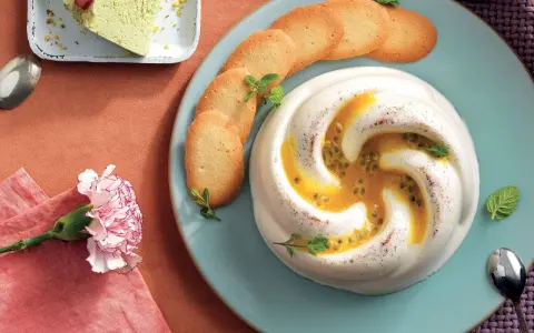 Deliziosa crema al latte con frutto della passione e biscotti, guarnita con menta. Un dolce invitante.