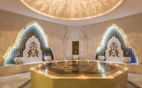 Luxuriöses Hamam Dampfbad mit Marmor, Mosaiken und Kerzenlicht.