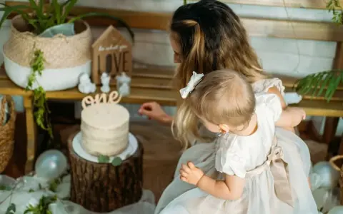 Mama z córką przy torcie na roczek. Piękny tort i dekoracje, idealne na prezent, co kladzie sie dziecku do wyboru na roczek.