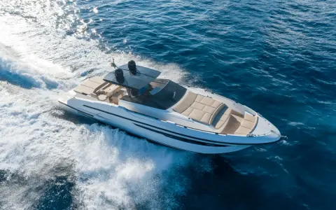 Yacht blanc filant sur l'eau bleue, créant une écume blanche. Idéal pour surveiller son bateau à distance.