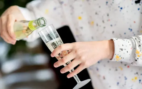 Sekt wird in ein Glas gegossen. Die Frage, wie lange ist Sekt haltbar, beschäftigt viele Genießer.