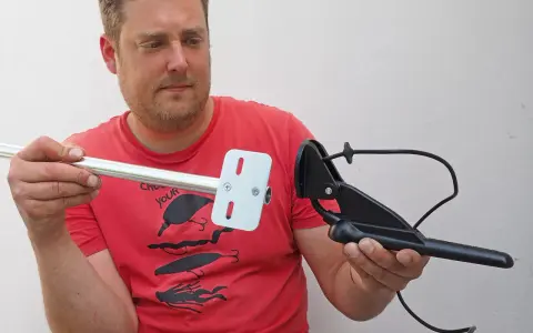 Mann hält Aluminiumrohr und Echolotgeber. Idee: Echolotgeberstange selber bauen für Angeltrip.