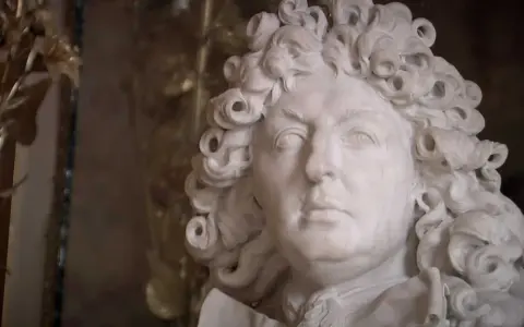 Marmorstatue eines Mannes mit Lockenperücke, die an die Pracht des Absolutismus erinnert.