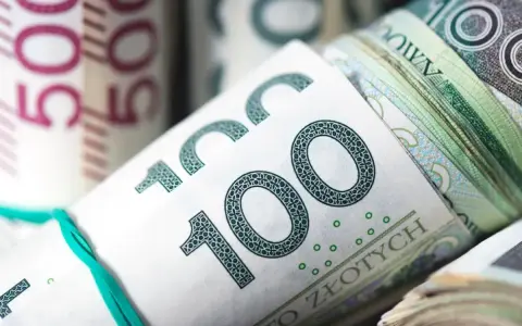 Zwijane banknoty 100 zł i 50 zł związane gumką.