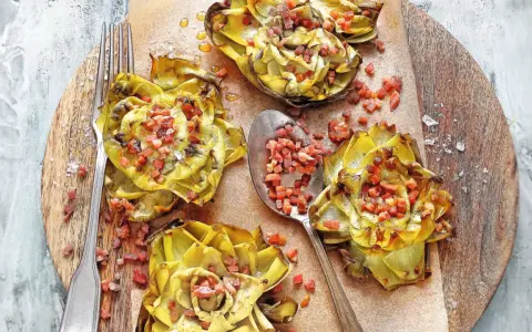 Deliciosas alcachofas al horno, doradas y rellenas de trocitos de jamón, listas para disfrutar.