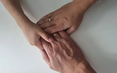 Dłonie dziecka i rodziców splecione na białym tle. Symbol nadziei na powrót do domu, jak w przypadku wniosku o odzyskanie dziecka z rodziny zastępczej wzór.