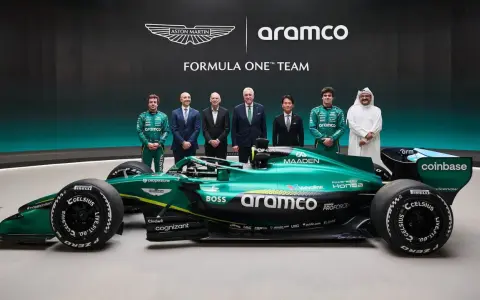 El equipo Aston Martin Aramco Cognizant Formula One Team posa junto a su coche verde brillante.