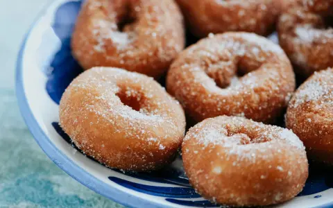 Rosquillas caseras de toda la vida, doradas y espolvoreadas con azúcar, listas para disfrutar.