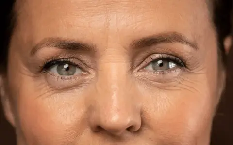 Primer plano de unos ojos con arrugas en los ojos a los 40, reflejando una vida de sonrisas y experiencias.