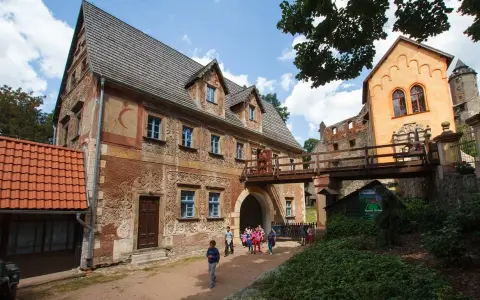 Zamek Książ i jego okolice to jedne z najpiękniejszych wałbrzych atrakcje. Drewniany most łączy zabytkowe budynki, a dzieci zwiedzają teren.
