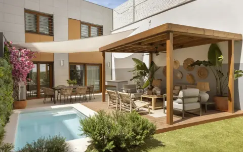 Modernos patios con piscina, zona de estar bajo pérgola de madera y comedor exterior.