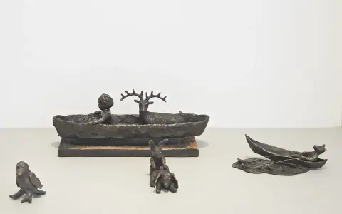 Bronsfigurer av Suzanne Nessim: ett barn och ett rådjur i en båt, kaniner och en fågel.