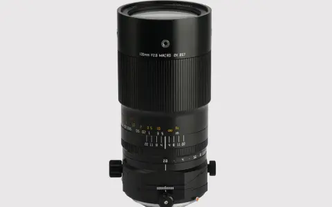 Czarny obiektyw makro 100mm f/2.8 z oznaczeniami odległości i przysłony.