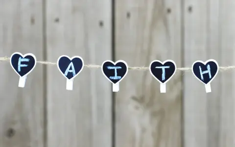 Five heart-shaped clothespins spell "FAITH" on a string, a reminder for prayers for children.