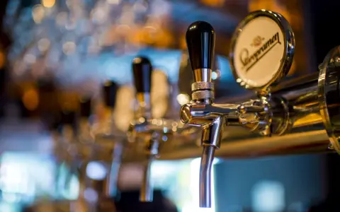 Grifos de cerveza en un bar, listos para servir. Un detalle que evoca el ambiente de un traspaso de bar exitoso.