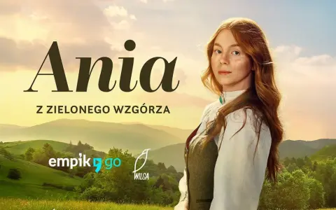 Ania z Zielonego Wzgórza, rudowłosa dziewczynka z piegami, patrzy zza zielonych wzgórz.