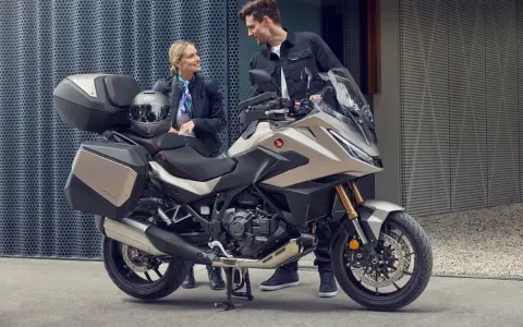 Para zwiedzająca motocykle z automatyczną skrzynią biegów. Nowoczesny design i praktyczne kufry zachęcają do wspólnych podróży.