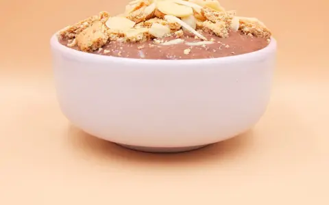 Czekoladowy pudding proteinowy z płatkami migdałów i pokruszonymi ciasteczkami. Czy pudding proteinowy jest zdrowy? To zależy od składników!