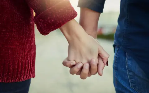 Mani che si stringono, simbolo del significato dell'ancora in amore: stabilità, sicurezza e un legame profondo che resiste alle tempeste.