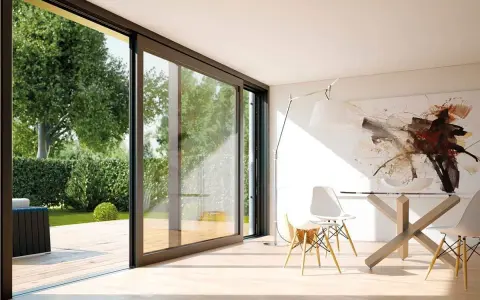 Amplias ventanas aislantes conectan un moderno comedor con un exuberante jardín.