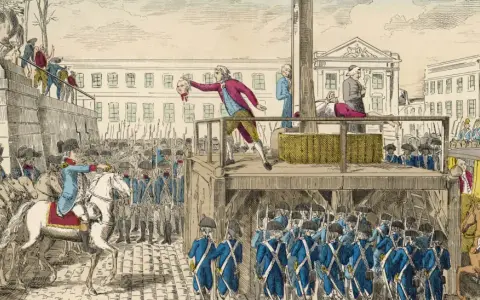 Ein Mann hält einen Kopf hoch, während die Guillotine in Frankreich bereitsteht. Soldaten und eine Menge beobachten die Hinrichtung.