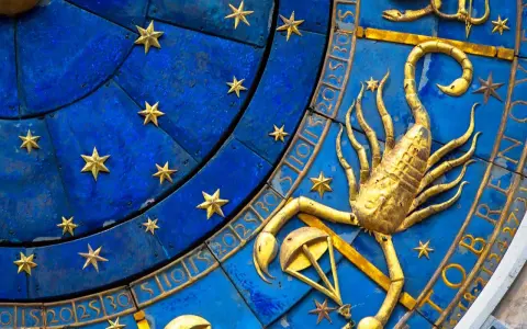 Złoty skorpion, symbol zodiaku, na niebieskiej tarczy z gwiazdami i cyframi.