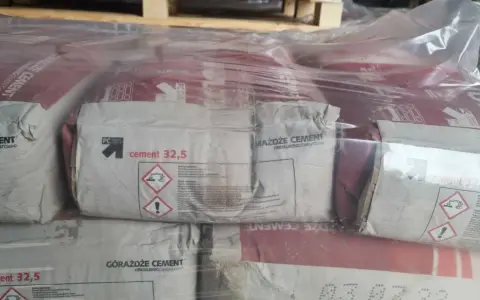 Stos cementu 32,5 kg w workach, owiniętych folią.
