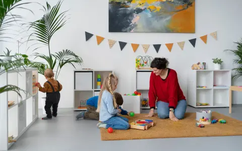 Bambini giocano in una stanza colorata, con scaffali pieni di giochi. Ottime idee stanza giochi bambini per un ambiente stimolante.