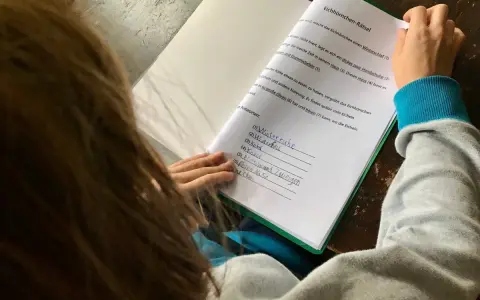 Kind löst ein Eichhörnchen-Rätsel, die Antworten sind bereits eingetragen. Eine leichte eskalation bei hausaufgaben, da die Antworten teils unleserlich sind.
