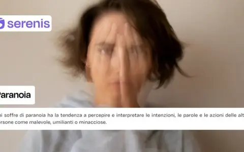 Una persona con il volto coperto dalle mani, con un'espressione turbata. Il testo parla di paranoia, descrivendo come chi ne soffre percepisce gli altri come pericolosi.
