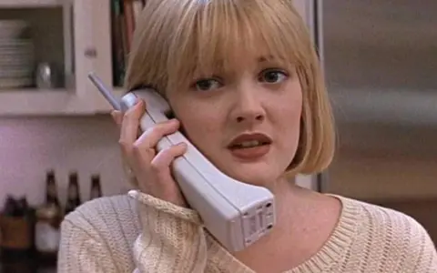 Blondynka z przerażeniem odbiera telefon, jakby właśnie usłyszała, że ktoś ją "zombieinguje".