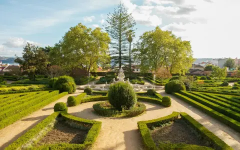 Ein barocker Garten mit Brunnen und akkurat geschnittenen Hecken vor dem Ajuda-Palast in Lissabon.