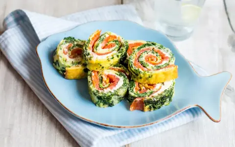 Rouladen mit Lachs und Spinat auf einem Fisch-Teller. Leckere Morbus Crohn Rezepte, die gut verträglich sind.