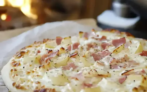 Flamenkuche, une tarte fine garnie de lardons et de crème, évoque son origine alsacienne.