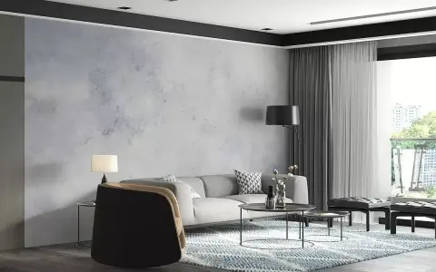 Nowoczesny salon z sofą, stolikami i dywanem. Ściana za sofą ma subtelny **efekt betonu**, nadając wnętrzu industrialny charakter.