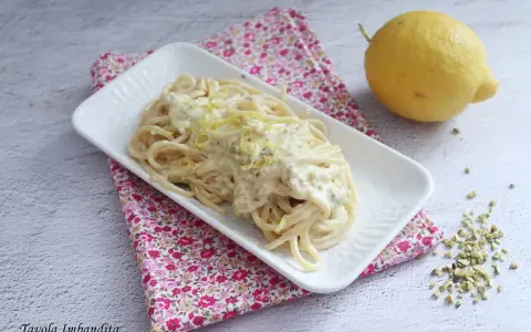Spaghetti al limone cremosi, un piatto invitante con scorza di limone grattugiata e pistacchi tritati.