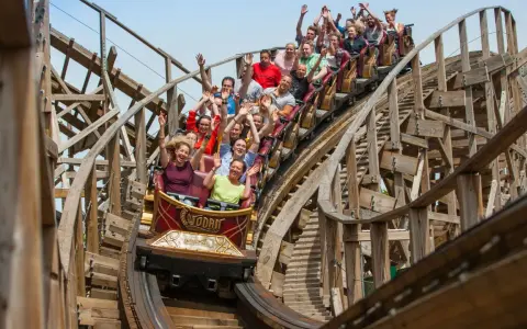 Menschen jubeln auf der Holzachterbahn "Wodan" im Europa-Park. Die rasante Fahrt sorgt für pure Freude und Adrenalin.
